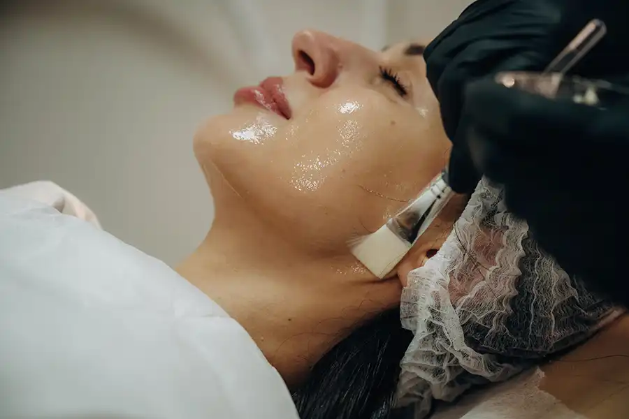Glass skin facial treatment in Dubai applying hydrating serums for poreless glow